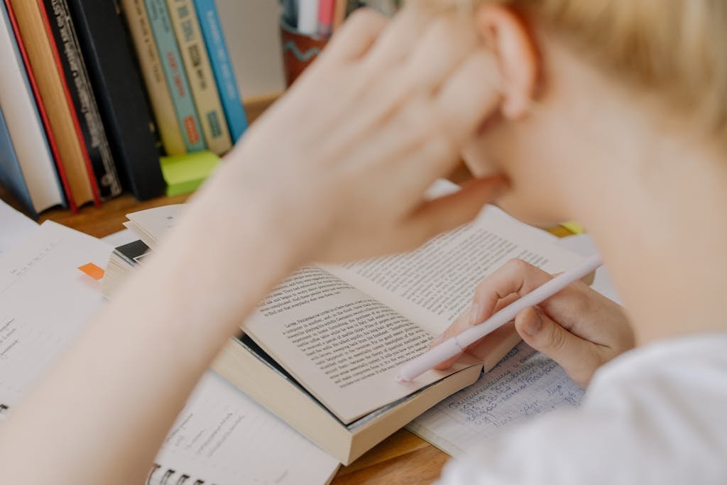 A student studying diligently with an open textbook, emphasizing concentration and learning.